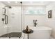 Elegant bathroom showcasing a glass-enclosed shower and freestanding tub with black fixtures, exuding modern luxury at 6040 Crittenden Ave, Indianapolis, IN 46220