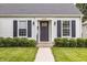 Close-up showcasing the front door, black shutters and lush green bushes at 6040 Crittenden Ave, Indianapolis, IN 46220