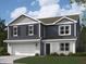 Charming two-story home featuring navy blue siding and a white brick foundation with an attached two-car garage at 61 Benfield Dr, Whiteland, IN 46184