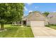 Charming brick home featuring an attached two-car garage and a well-maintained lawn and mature shade tree at 6369 Clary Ln, Greenwood, IN 46143