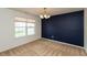 Neutral living room with a large window, carpet and dark blue accent wall at 6369 Clary Ln, Greenwood, IN 46143