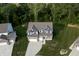 Aerial view of a landscaped home featuring a brick and vinyl exterior, a two-car garage, and lush lawn at 6377 Harvey Dr, Plainfield, IN 46168