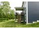 Exterior view of a backyard featuring a staircase to a covered porch and a well-maintained lawn at 6377 Harvey Dr, Plainfield, IN 46168