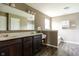 Modern bathroom featuring a double vanity with dark cabinets, a large mirror and a separate shower at 6377 Harvey Dr, Plainfield, IN 46168
