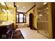 Well-lit bathroom featuring a spacious walk-in shower, soaking tub, and large windows at 6412 Fall Creek Rd, Indianapolis, IN 46220
