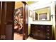 The bathroom boasts a dark wood vanity, a large mirror, and a shower with a decorative curtain at 6412 Fall Creek Rd, Indianapolis, IN 46220