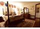 Bedroom featuring a four poster bed, dark wood floors and furniture, and shield decor at 6412 Fall Creek Rd, Indianapolis, IN 46220