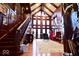 Grand foyer with soaring ceilings, a stunning staircase, rich wood paneling, and abundant natural light at 6412 Fall Creek Rd, Indianapolis, IN 46220
