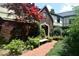 Beautiful brick home with Tudor accents and landscaped front yard with stone bench, adding charm and curb appeal at 6412 Fall Creek Rd, Indianapolis, IN 46220