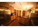 Open-concept kitchen featuring wooden cabinets, granite countertops, stainless steel appliances, and an adjacent brick accent wall at 6412 Fall Creek Rd, Indianapolis, IN 46220