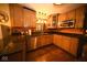 Traditional kitchen featuring wood cabinetry, granite counters, stainless steel appliances, and warm pendant lighting at 6412 Fall Creek Rd, Indianapolis, IN 46220