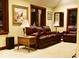 Cozy living room with dark wooden trim, leather furniture, and historic artwork at 6412 Fall Creek Rd, Indianapolis, IN 46220