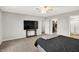 Well-lit bedroom with neutral walls, carpet, ceiling fan, and a sizable television at 6645 Honeysuckle Way, Pendleton, IN 46064