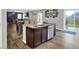 Open kitchen features a center island with granite countertops and stainless steel appliances overlooking the living and dining areas at 6645 Honeysuckle Way, Pendleton, IN 46064