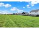 A view of the neighborhood with green grass and a bright blue sky on a sunny day at 6645 Honeysuckle Way, Pendleton, IN 46064
