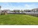Large, grassy backyard with a wooden fence and neighboring houses in view at 6923 Bryant Pl, Plainfield, IN 46168