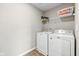Functional laundry room with a washer, dryer, storage shelf, and durable vinyl flooring at 6923 Bryant Pl, Plainfield, IN 46168