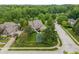 Aerial view of a house surrounded by mature trees and a well-manicured lawn, with cars in the driveway at 7141 Ember Ct, Indianapolis, IN 46236