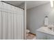 A clean and well-lit bathroom featuring a toilet, vanity with sink, and a shower with a decorative curtain at 7141 Ember Ct, Indianapolis, IN 46236