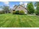 Beautifully landscaped home with a brick exterior, manicured lawn, mature trees, and an attached garage at 7141 Ember Ct, Indianapolis, IN 46236