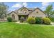 Charming two-story brick home with a lush green lawn and manicured landscaping at 7141 Ember Ct, Indianapolis, IN 46236