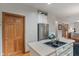 Kitchen featuring stainless steel refrigerator, island cooktop, hardwood floors, and view to living area at 7141 Ember Ct, Indianapolis, IN 46236