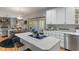 Kitchen featuring white cabinets, island cooktop, hardwood floors, and a view into the living room at 7141 Ember Ct, Indianapolis, IN 46236