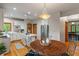 Bright kitchen featuring white cabinets, stainless steel appliances, and a dining area with wood table at 7141 Ember Ct, Indianapolis, IN 46236