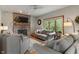 Cozy living room featuring a brick fireplace, comfortable seating, and a large window at 7141 Ember Ct, Indianapolis, IN 46236