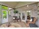Cozy screened porch featuring wicker furniture, brick accents, and outdoor lighting at 7141 Ember Ct, Indianapolis, IN 46236