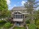 Charming home featuring a screened-in porch and a lower patio area with a swing, surrounded by lush greenery at 7141 Ember Ct, Indianapolis, IN 46236