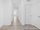 Bright hallway featuring wood-look floors, white walls, and multiple doors leading to various rooms at 7431 Stillness Dr, Indianapolis, IN 46268