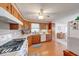 A classic style kitchen with wood cabinets, white appliances, and a view into the dining area at 8120 Trevellian Way, Indianapolis, IN 46217