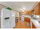 Bright kitchen with wood floors, white appliances, and wood cabinets at 8120 Trevellian Way, Indianapolis, IN 46217
