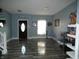 A light-blue room with new wood floors, a decorative door, and a white staircase at 8609 Wheatfield Dr, Camby, IN 46113