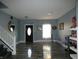 A light-blue room with new wood floors, a decorative door, and a white staircase at 8609 Wheatfield Dr, Camby, IN 46113