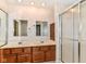 Bathroom featuring a double sink vanity with dark wood cabinets and a stand-up shower at 8713 Champions Dr, Indianapolis, IN 46256