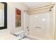A tiled bathtub-shower combo, a commode, and framed wall art create a calm bathroom at 8713 Champions Dr, Indianapolis, IN 46256