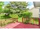 Red wooden deck off home with lush yard and trees at 8713 Champions Dr, Indianapolis, IN 46256