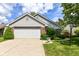 Charming home featuring a two-car garage, brick accents and well manicured landscaping at 8713 Champions Dr, Indianapolis, IN 46256
