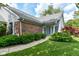 View of the home's entrance with brick accents, landscaping, and a walkway leading to the front door at 8713 Champions Dr, Indianapolis, IN 46256