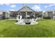 Large backyard boasts a patio with grilling area, fire pit, Adirondack seating, and lush green grass at 998 Cherry Tree Ln, Greenwood, IN 46143