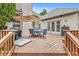 Outdoor back deck featuring an umbrella-covered dining table, grill, and wooden railing at 10697 Woodmont Ln, Fishers, IN 46037