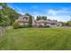 View of the large lawn and backyard of the home, featuring a wooden deck at 10697 Woodmont Ln, Fishers, IN 46037