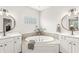 Luxurious bathroom featuring dual vanities and a soaker tub at 10697 Woodmont Ln, Fishers, IN 46037