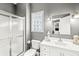 Clean bathroom with a shower, glass block window, and white vanity at 10697 Woodmont Ln, Fishers, IN 46037