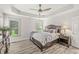 Comfortable bedroom with tray ceiling, ceiling fan, and lots of natural light at 10697 Woodmont Ln, Fishers, IN 46037