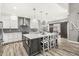 This modern kitchen boasts an island, stone countertops, stylish pendant lighting, and stainless steel appliances at 10697 Woodmont Ln, Fishers, IN 46037