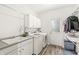 Bright laundry room with white cabinets, modern appliances, and access to the outside at 10697 Woodmont Ln, Fishers, IN 46037