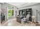 This home office features a built-in bookcase, large windows, and wood flooring at 10697 Woodmont Ln, Fishers, IN 46037